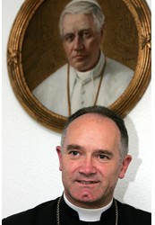 Bishop Bernard Fellay, superior general of the Society of St. Pius X, is seen near a portrait of Pope Piux X in Econe, Switzerland, in this Sept. 17, 2004, file photo.